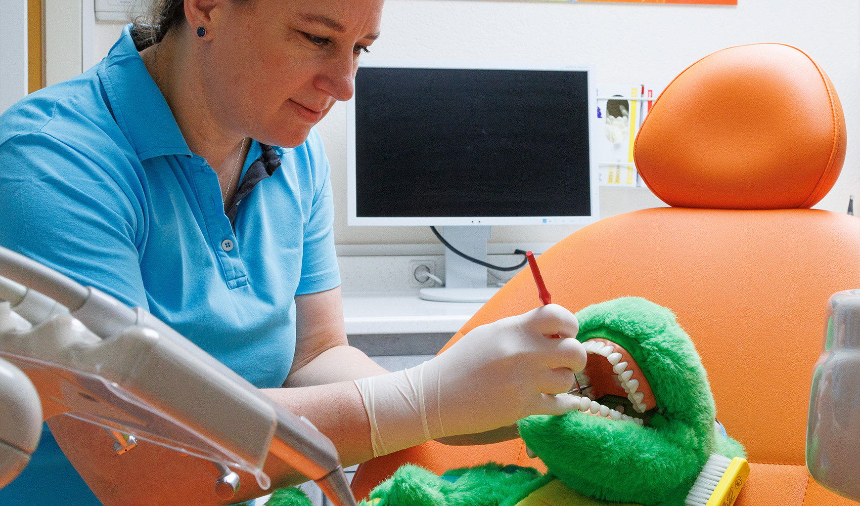Zahnärztin zeigt an Stoff-Krokodil wie eine Kontrolle abläuft